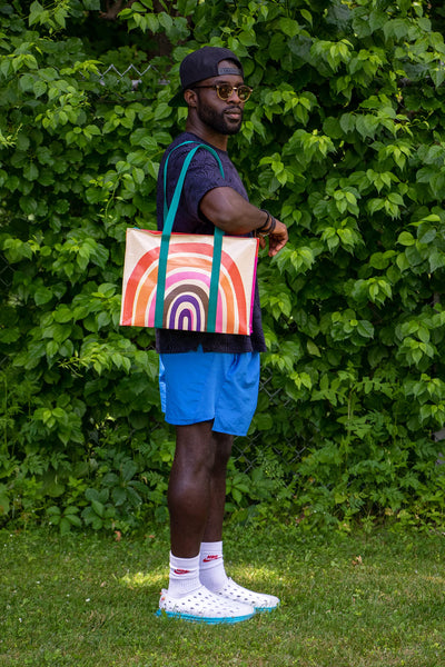 Blue Q Rainbow Shoulder Tote is the carry-everywhere bag featuring a hefty zipper, exterior pocket, wrap-around straps, reinforced floor, 95% recycled material, 11" h x 15" w x 6.25" d